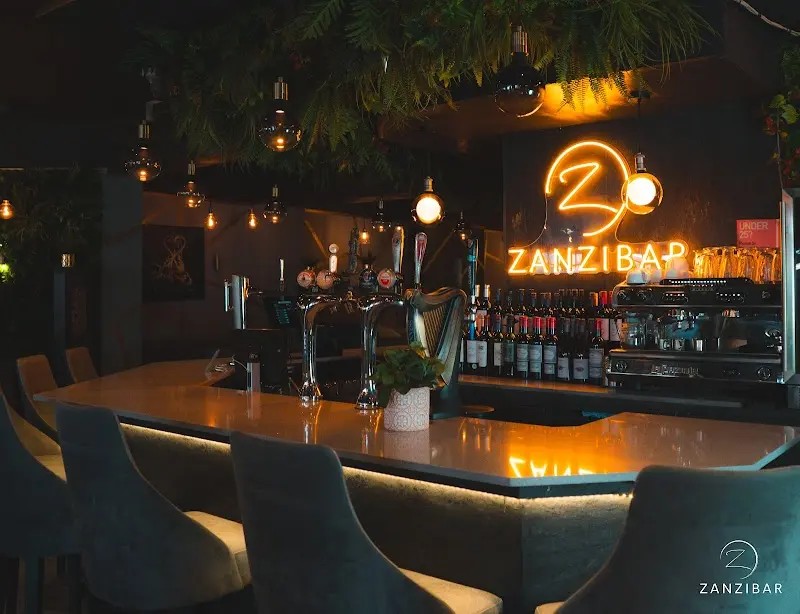 Inside Zanzibar Bar, glowing with its signature neon sign.